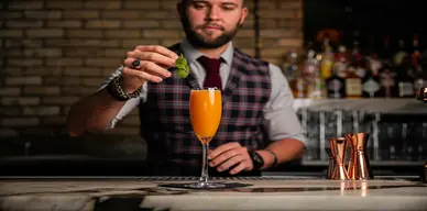Bartender expertly mixing a cocktail at a sleek corporate event in downtown St. Louis